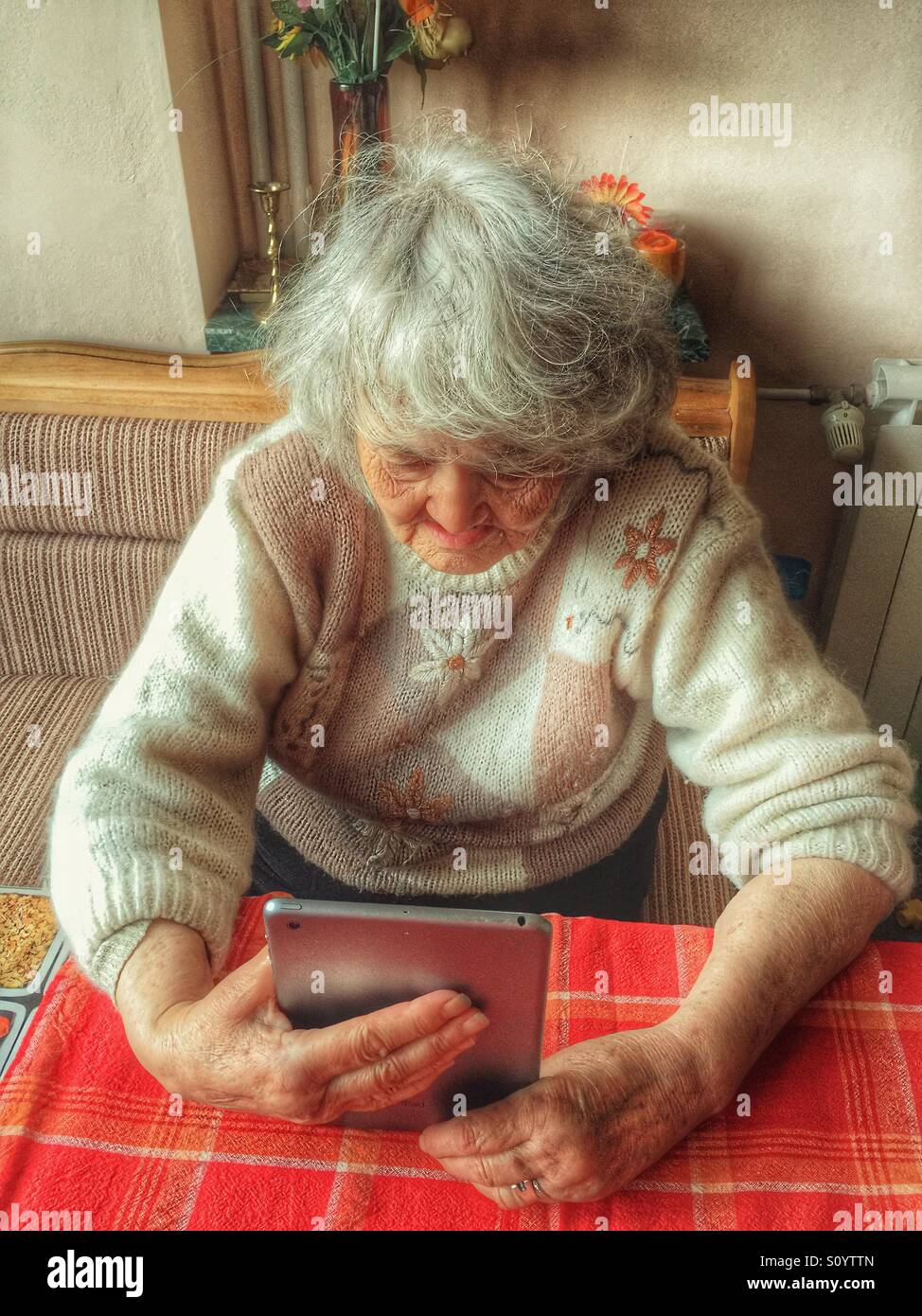 Senior woman using computer tablet at home - Smartphone Captured Stock Image