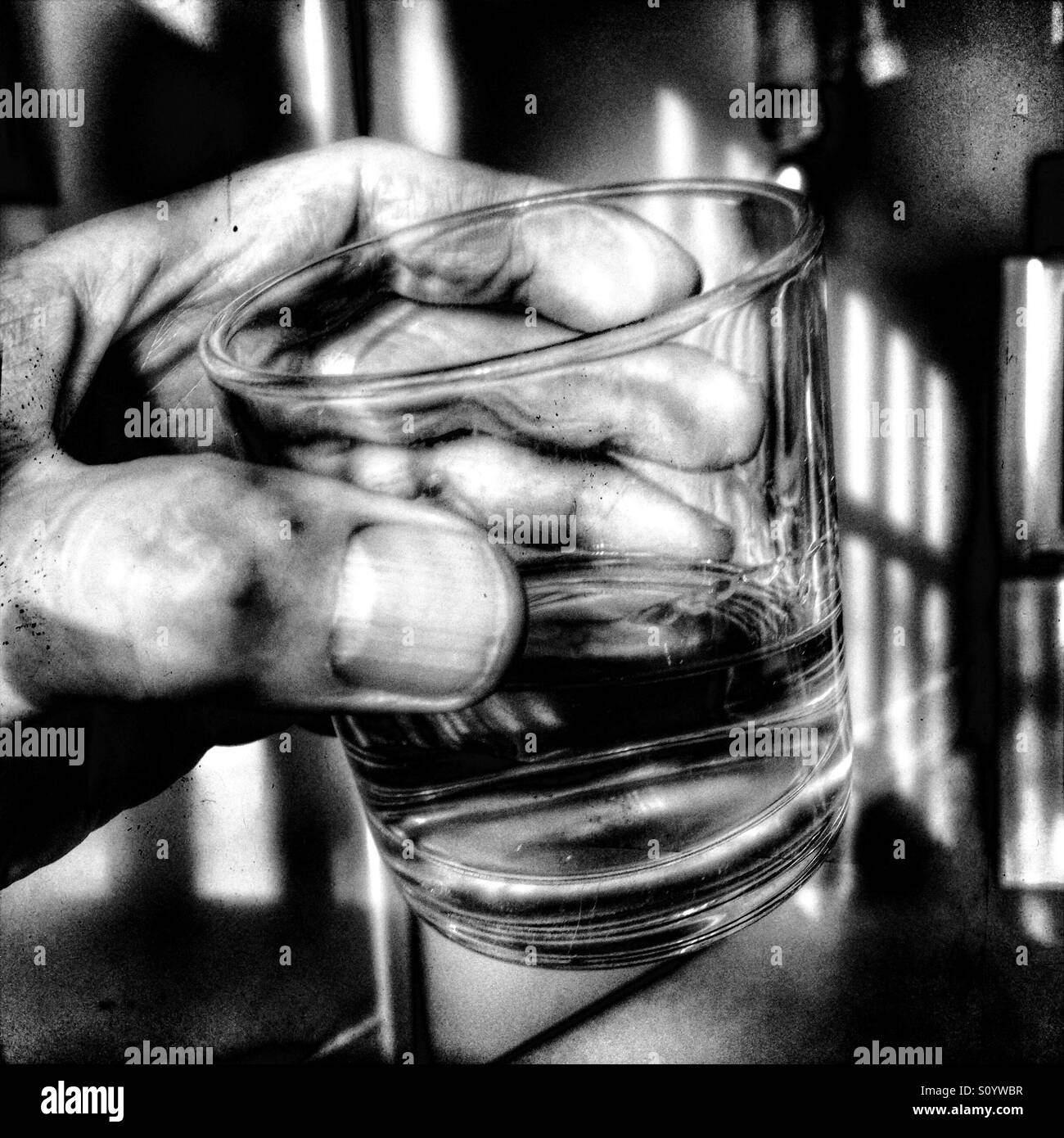 Mans hand holding glass of whisky - Smartphone Captured Stock Image