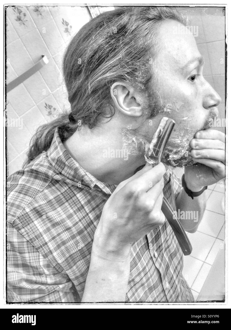 Shaving beard with cut-throat razor. - Smartphone Captured Stock Image