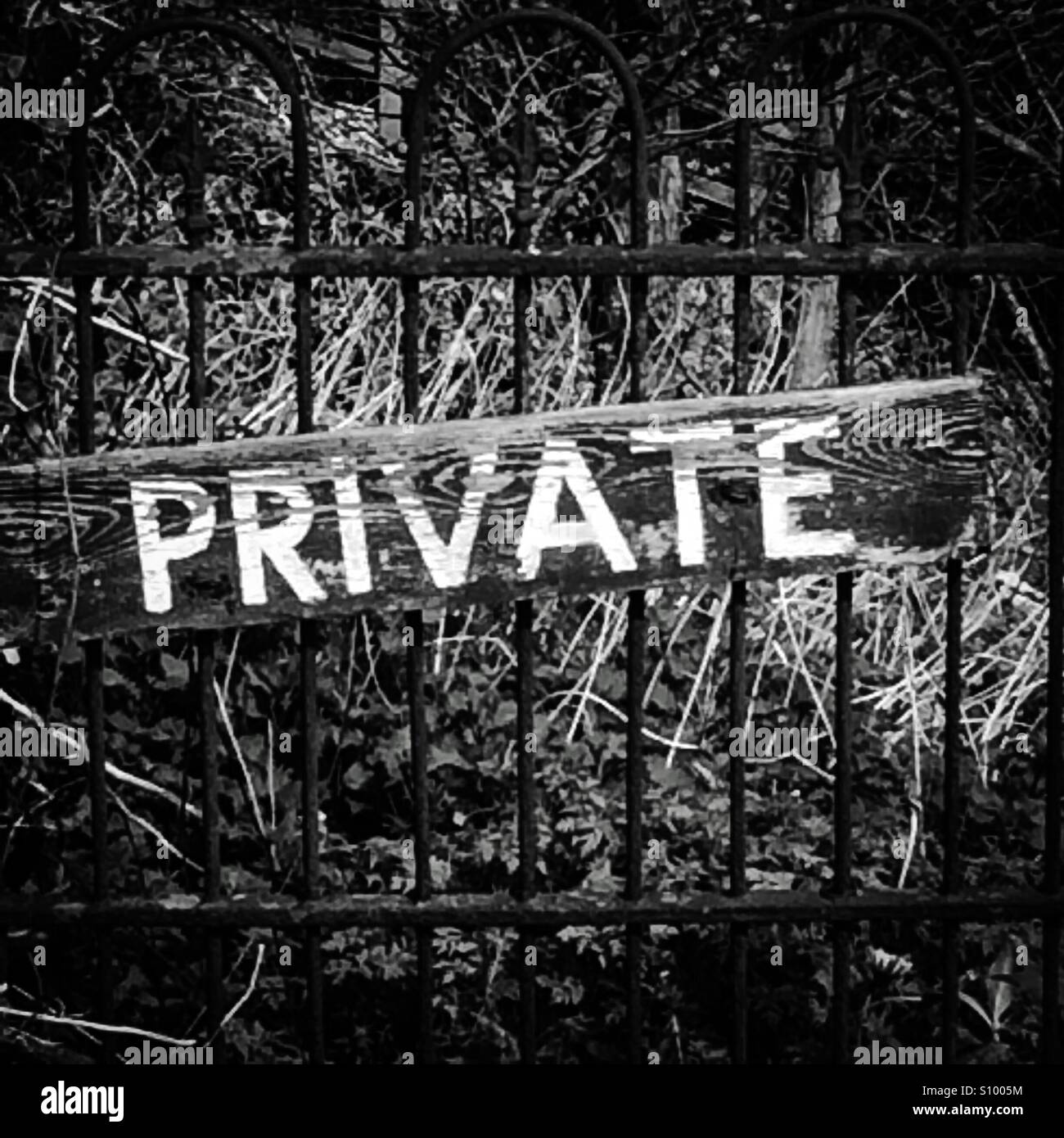 Black and white photograph of a Private sign on an old metal gate Stock