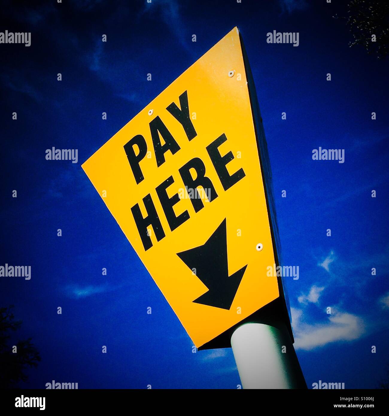 Pay Here sign with blue sky behind Stock Photo