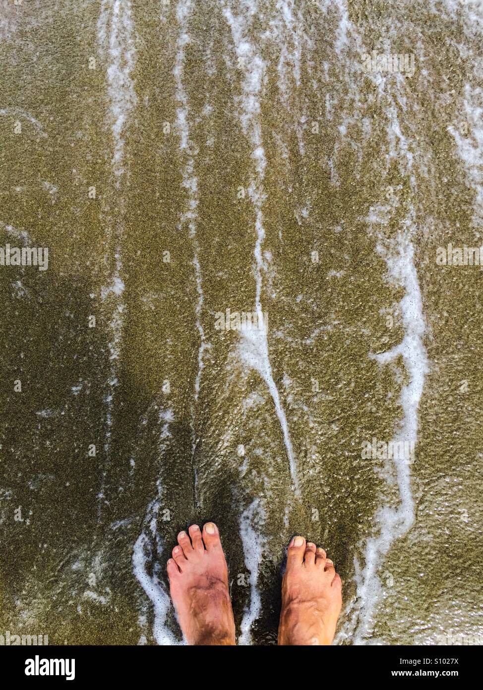 Ocean waves wash hiker's tired feet - Smartphone Captured Stock Image