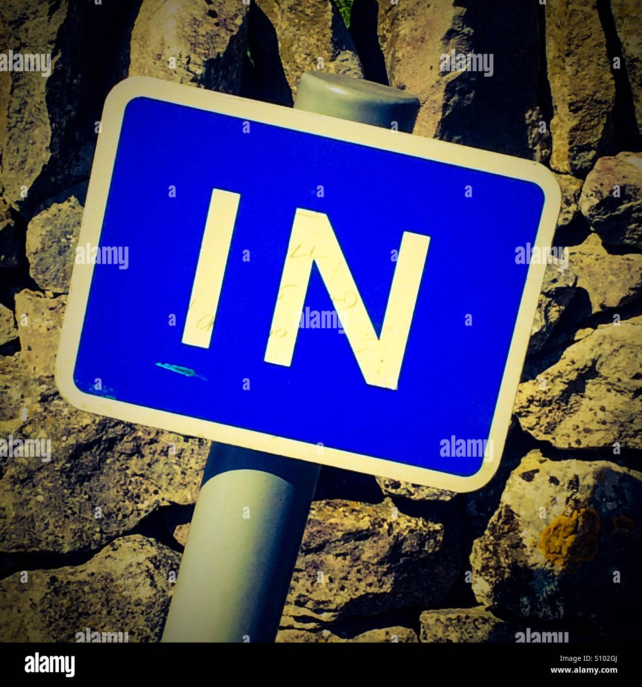 Close up view of blue IN sign with white letters - Smartphone Captured Stock Image
