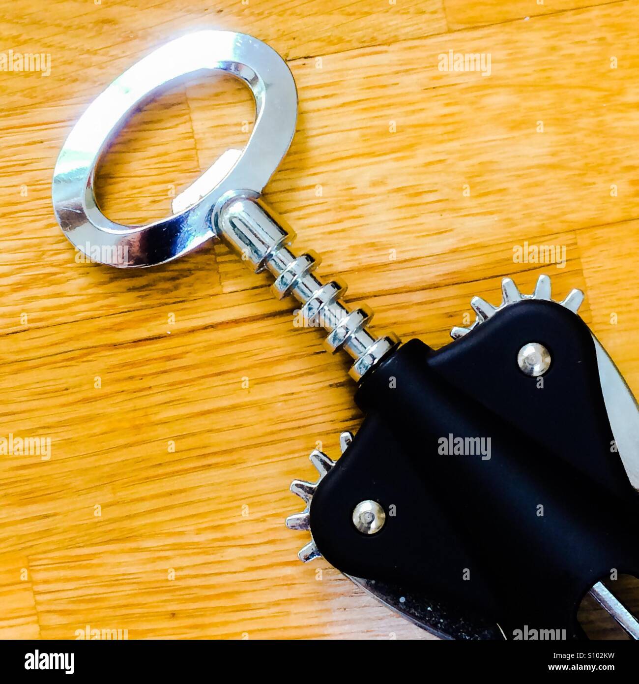 Close up view of the handle of a corkscrew on a wooden table - Smartphone Captured Stock Image