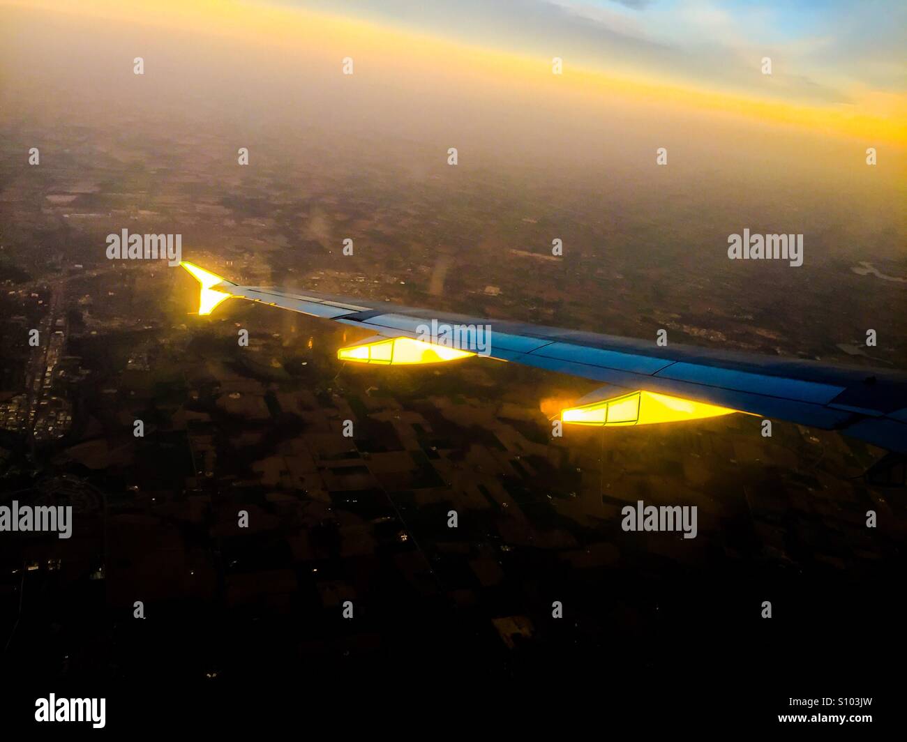 Plane at sunset, from a window seat on a regular commercial flight. Approaching dusk. Remains of a day. - Smartphone Captured Stock Image
