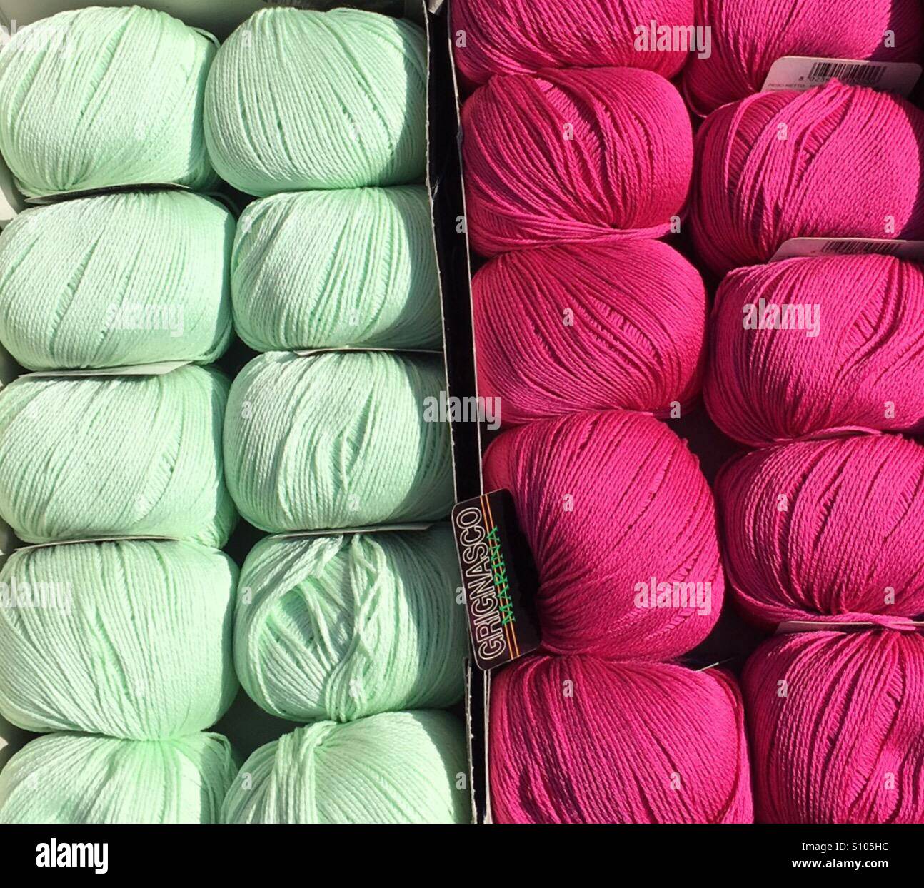 Pink and green balls of wool for sale at a market in Levanto, Italy Stock Photo