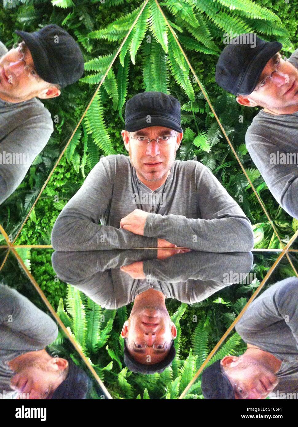 Kaleidoscope. Determined man in green leaves reflections & mirrors Stock Photo