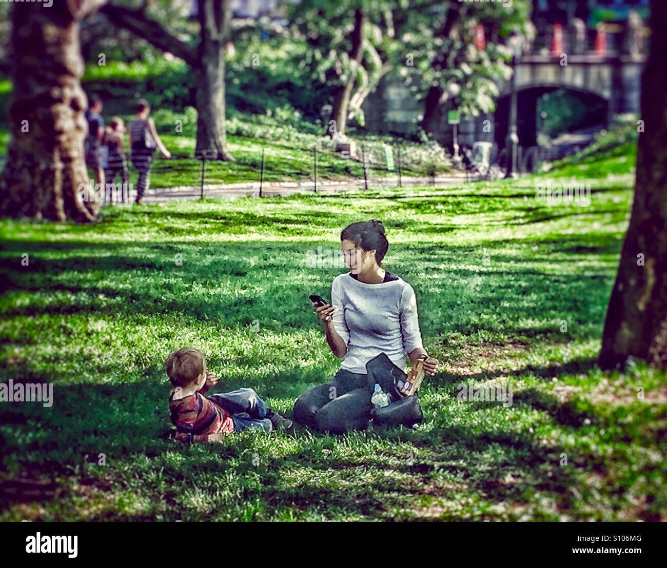 Young mother taking picture of her son in the park Stock Photo