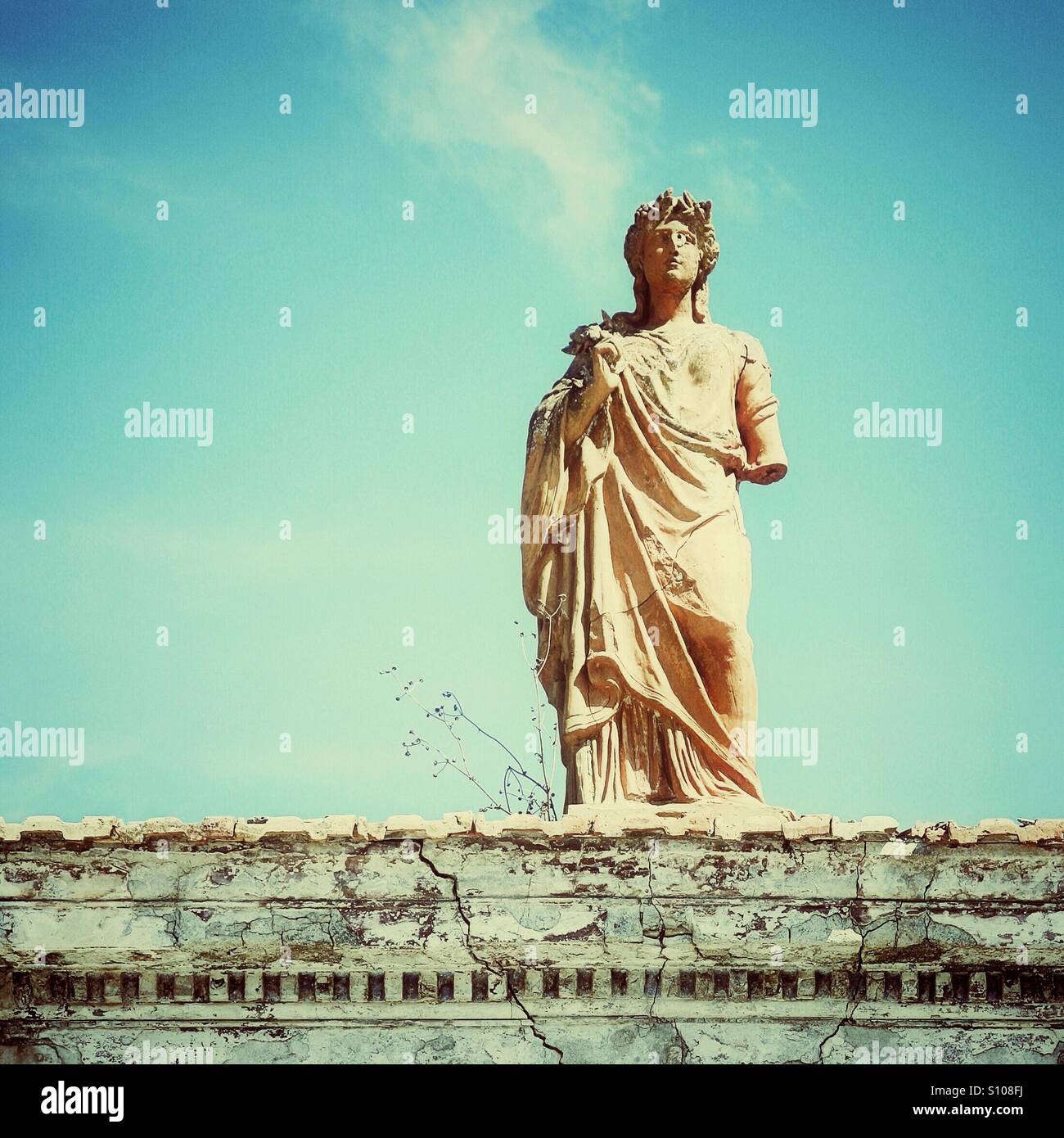 Ancient greek statue of female goddess on top of pediment Stock Photo