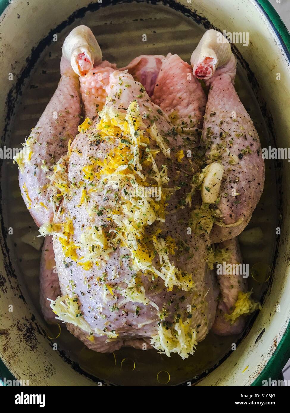 Roast dinner chicken in pot with lemon garlic and oregano Stock Photo