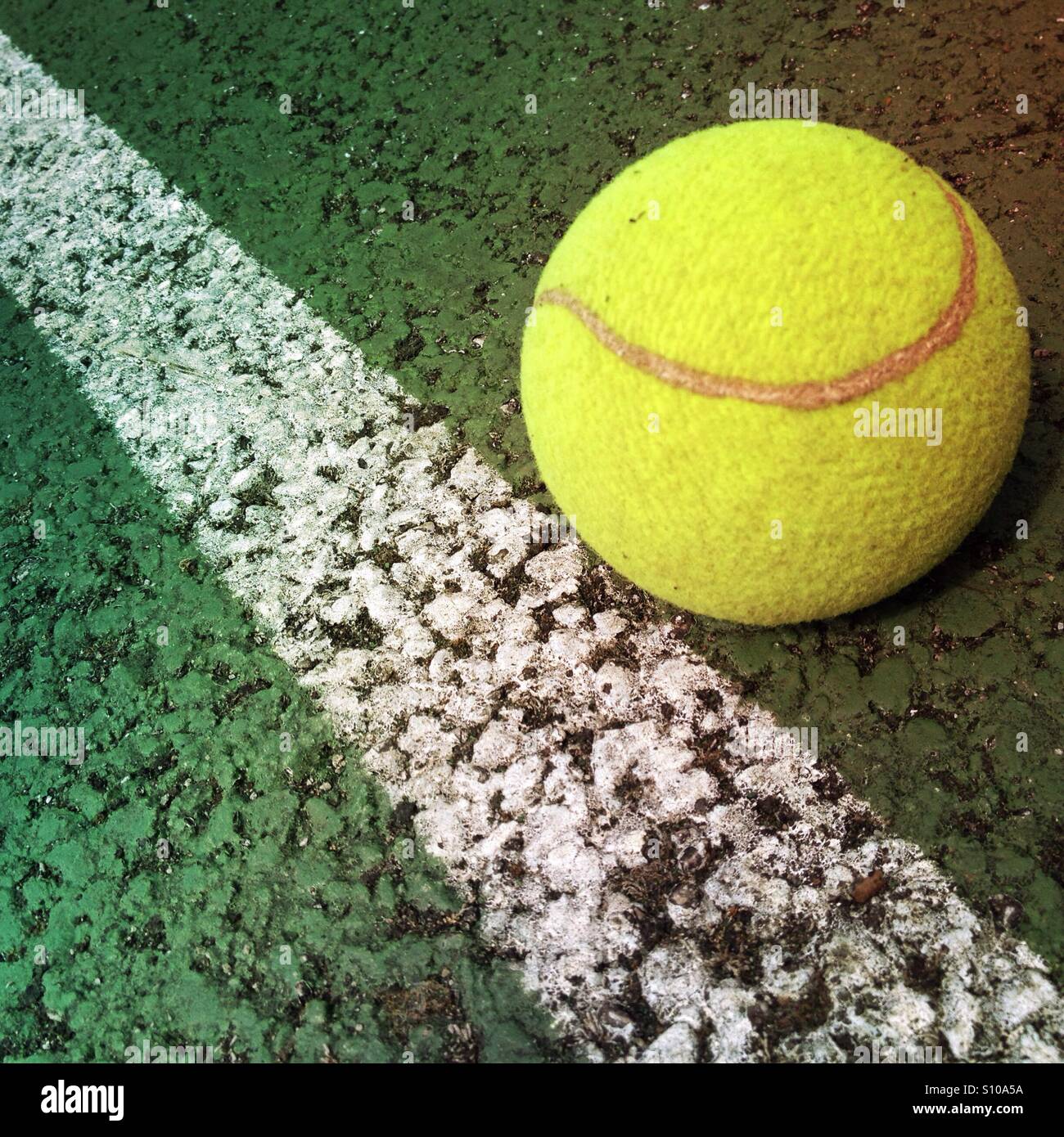 Tennis ball at the side of a tennis court line Stock Photo