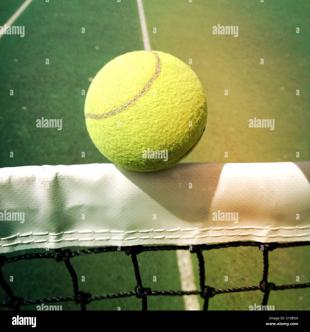 Tennis ball hitting the centre net of a tennis court Stock Photo