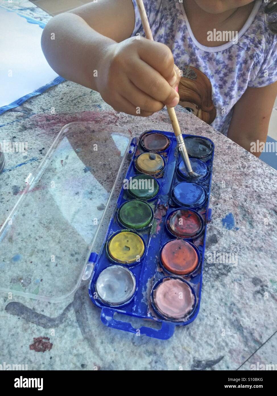 Little girl painting with watercolors Stock Photo - Alamy