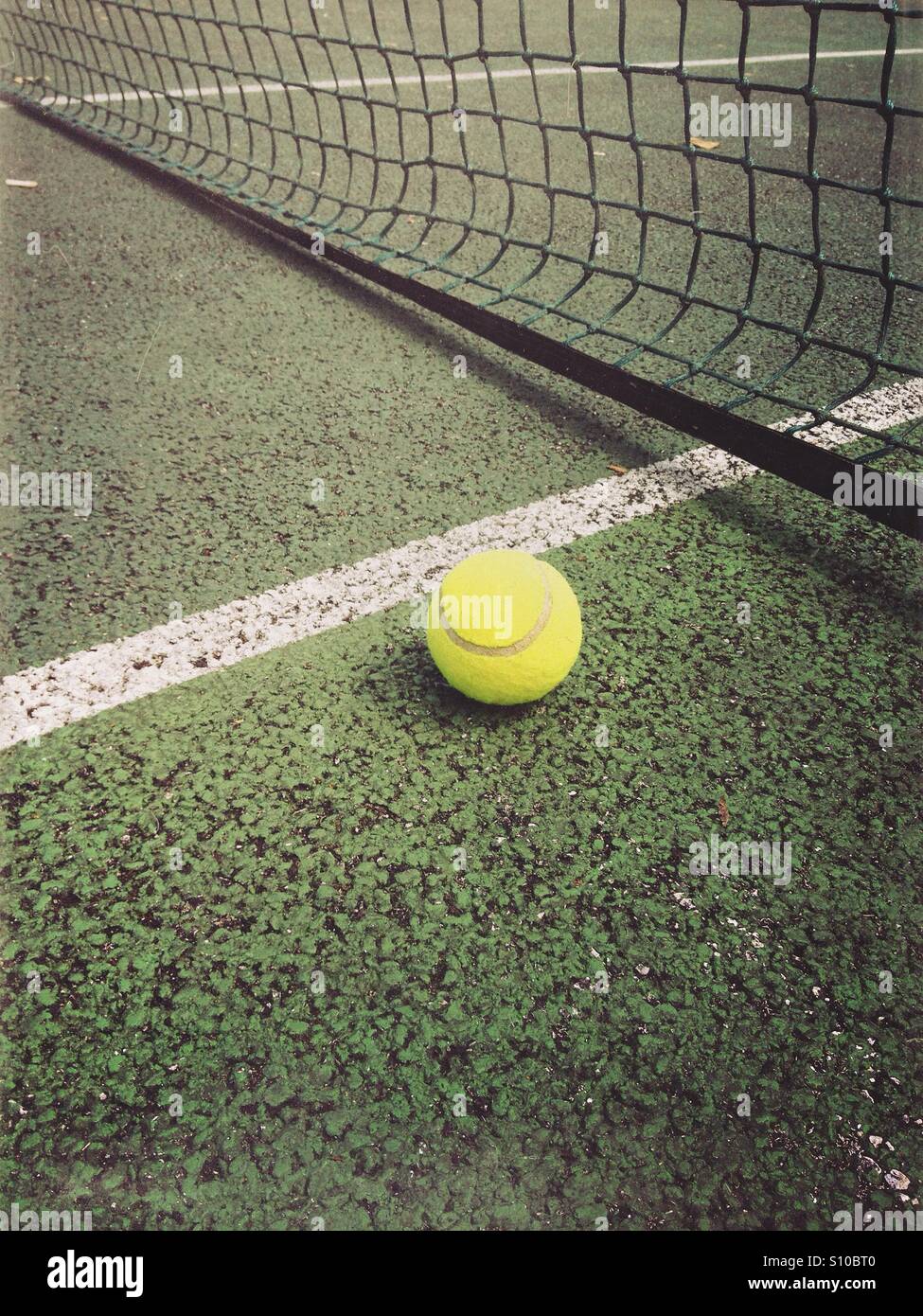 Tennis ball near a net and white line on a tennis court Stock Photo