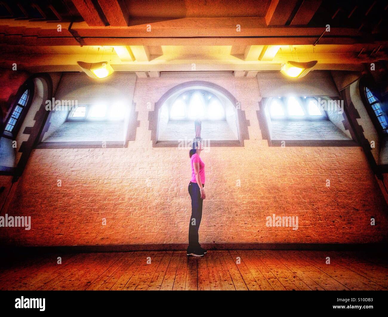 A young woman standing still and looking up - Smartphone Captured Stock Image