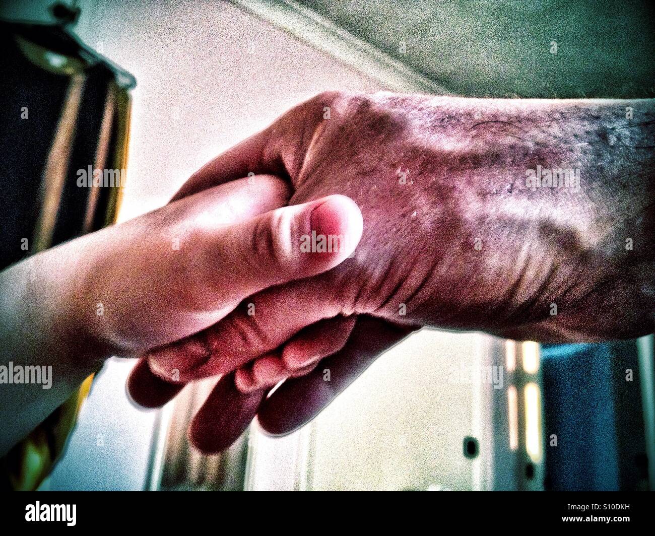 An adult male hand holding a young child's hand Stock Photo - Alamy