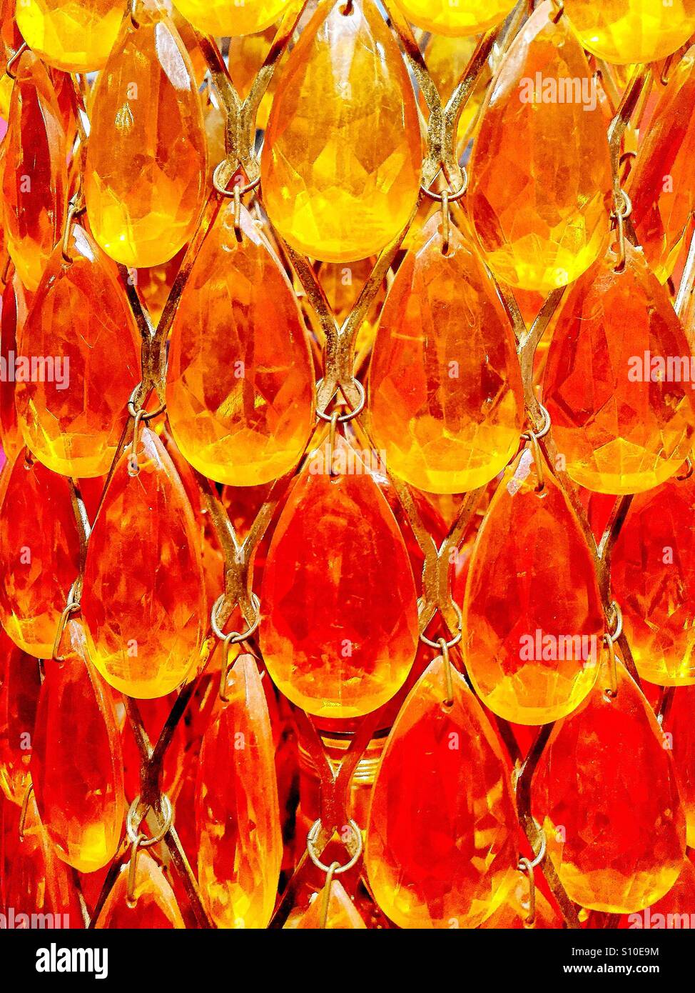 A close up view of bright orange and yellow shaded crystal glass drops. - Smartphone Captured Stock Image