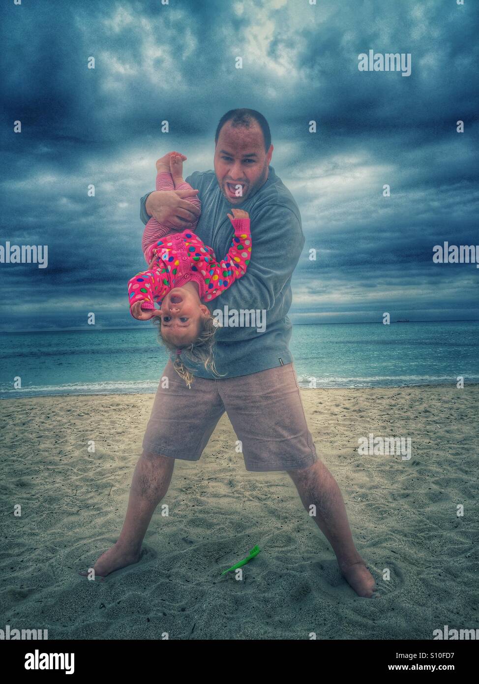 Father and baby girl playing on the beach Stock Photo