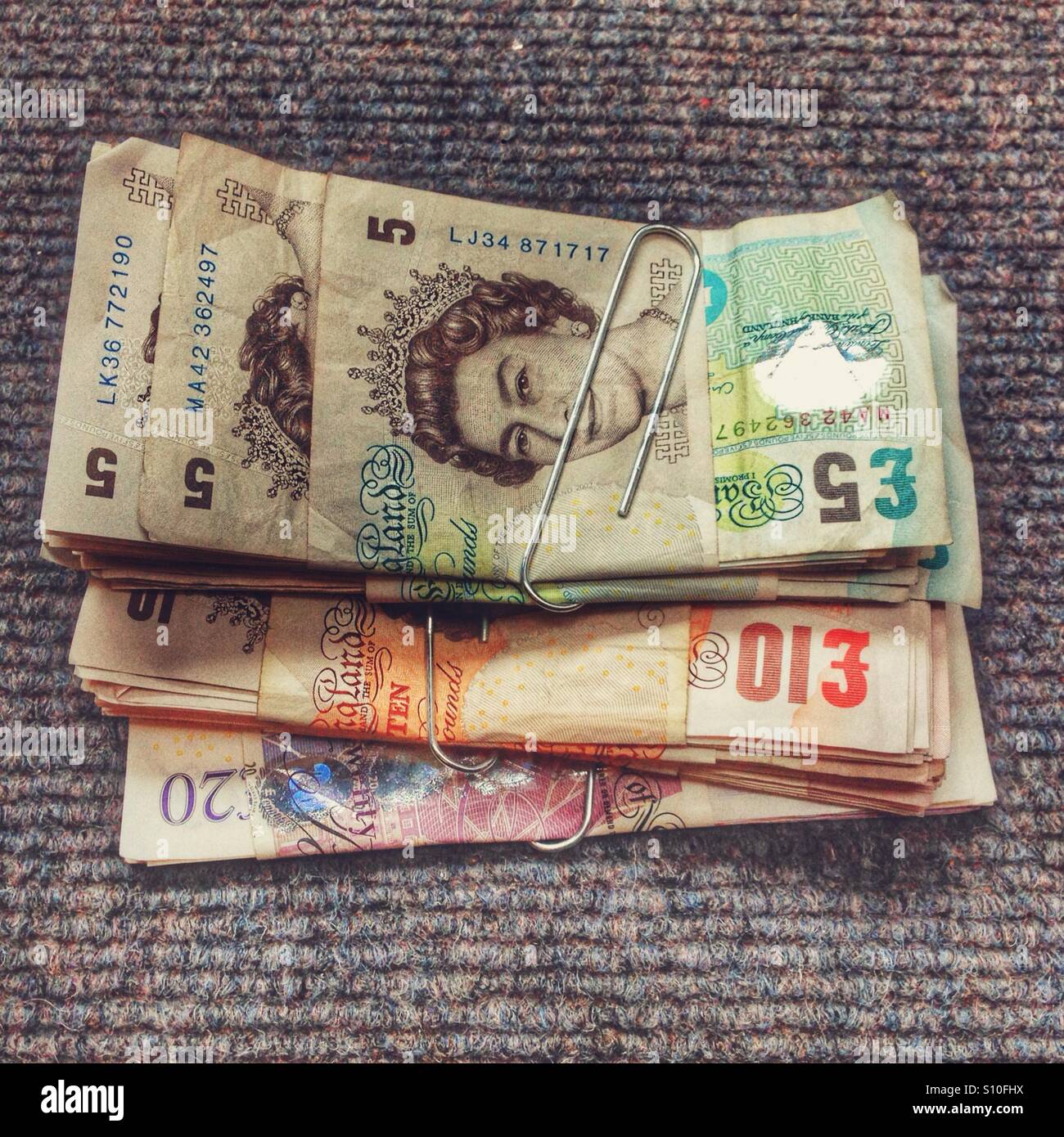 Stacks of British currency arranged on a textured surface during a financial transaction or currency exchange setting - Smartphone Captured Stock Image