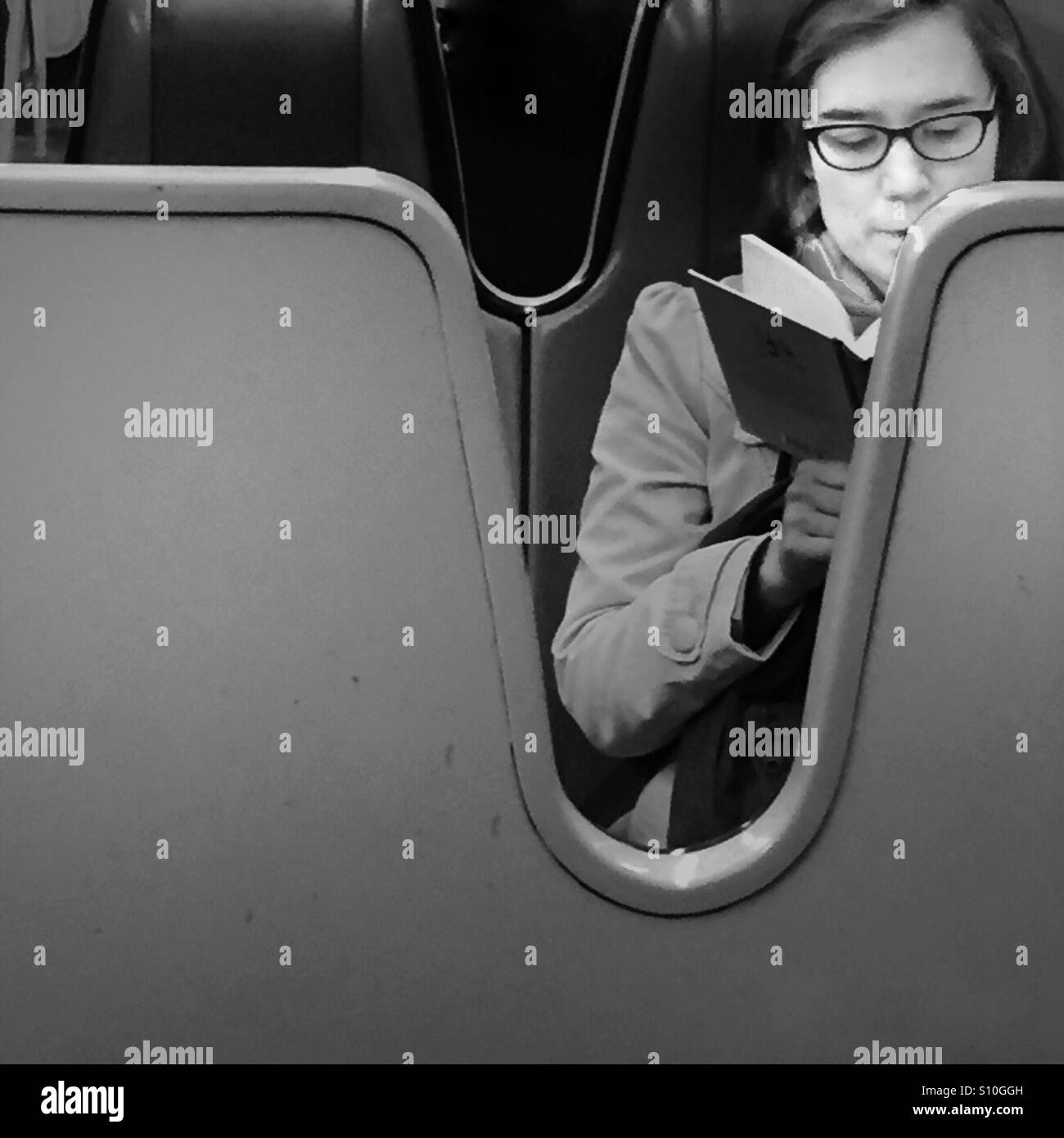 Woman reading a book on the subway Stock Photo