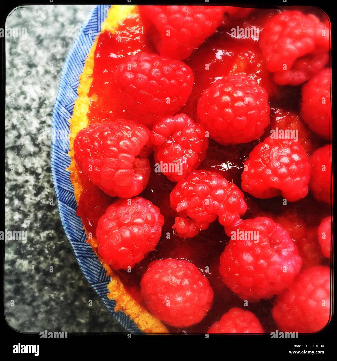 Half a raspberry cake on the kitchen work surface Stock Photo