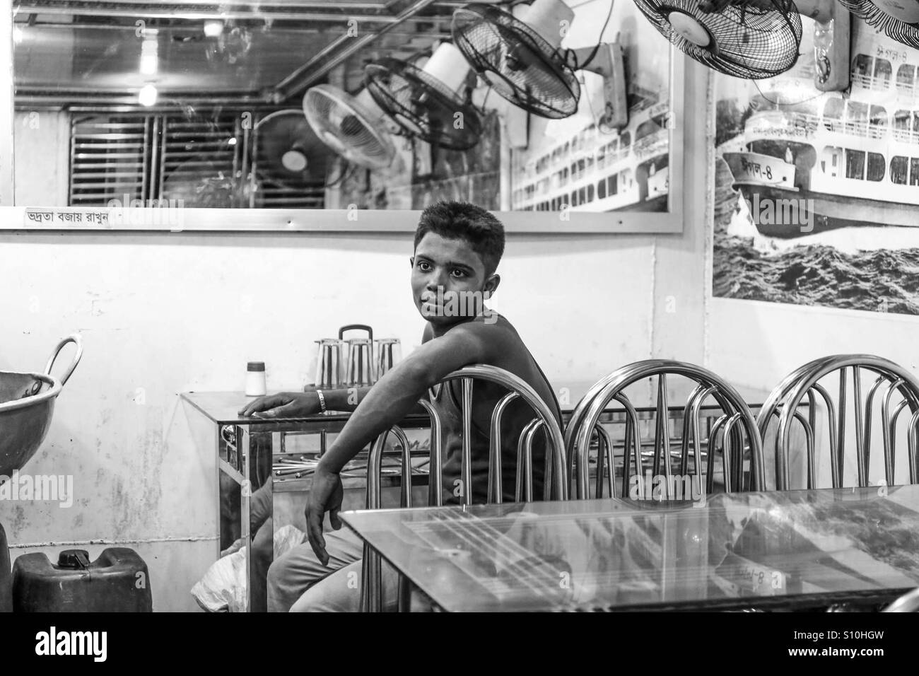 Child worker sitting desperate in restaurant Stock Photo