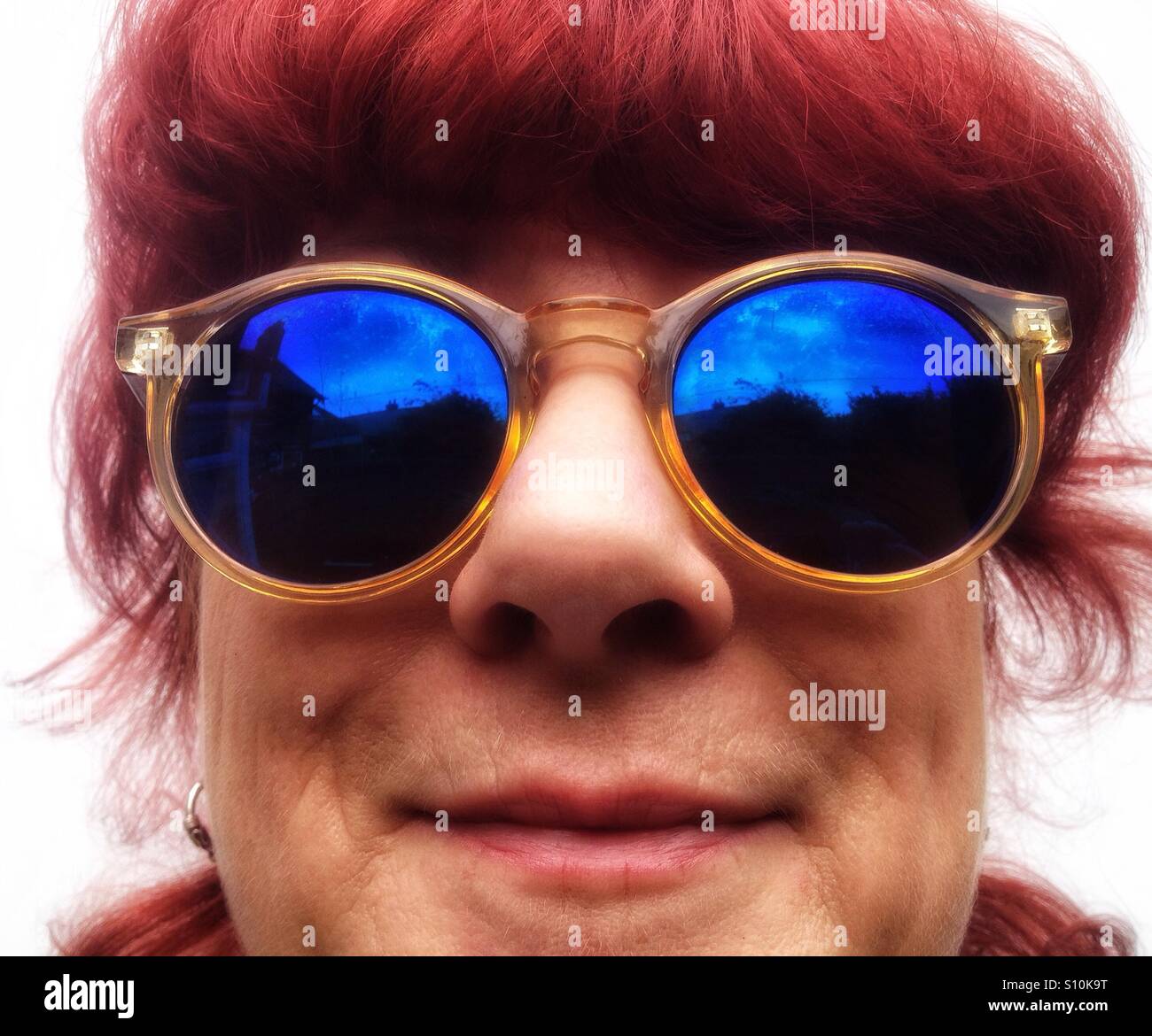 Woman with dyed red hair wearing mirror sunglasses - Smartphone Captured Stock Image