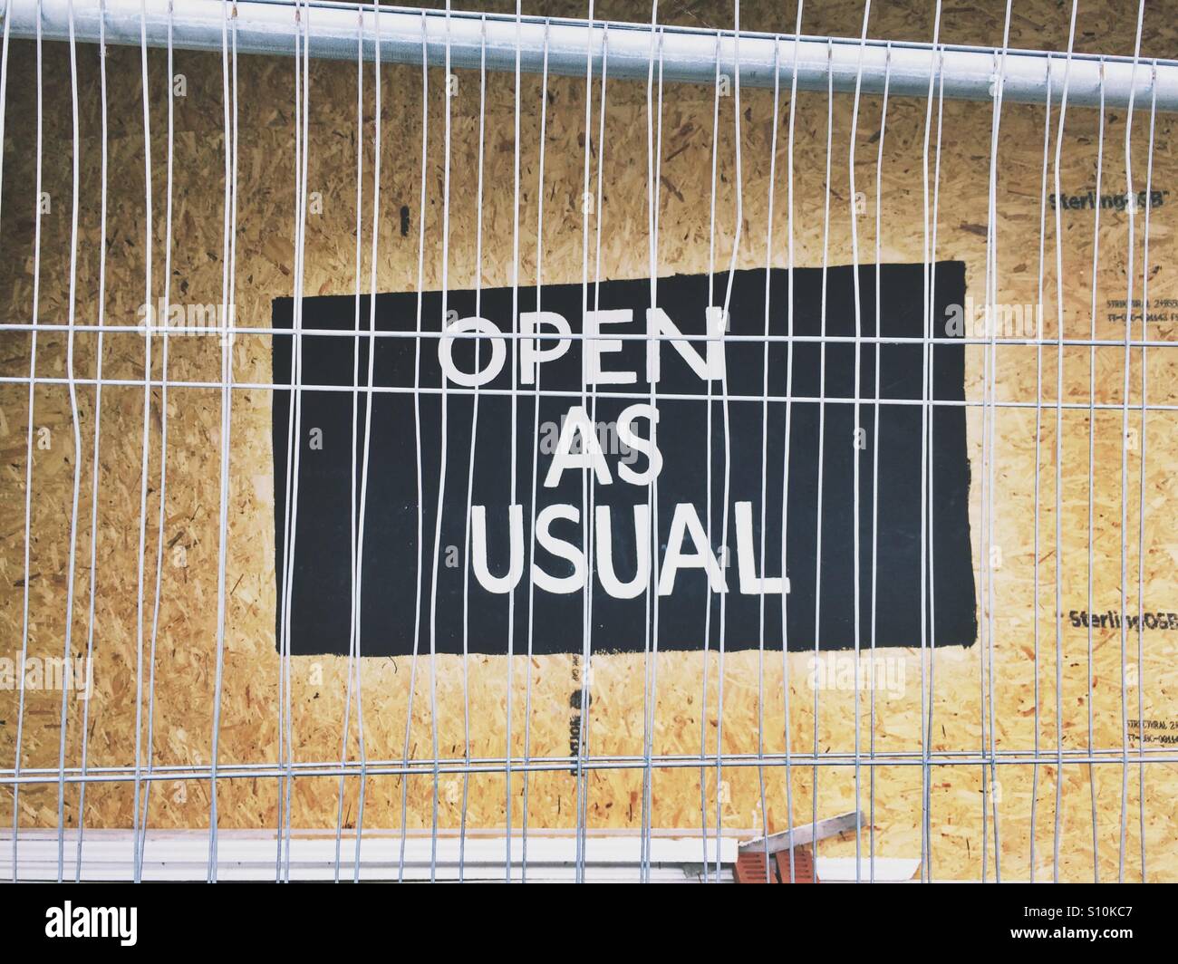 Open as usual sign in a shop window display - Smartphone Captured Stock Image Open as usual sign in a shop window display - Smartphone Captured Stock Image