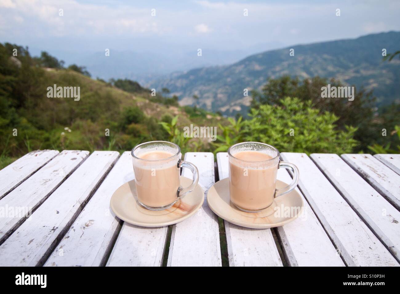 Two cups of masala tea on the table with mountain view, Nepal Stock
