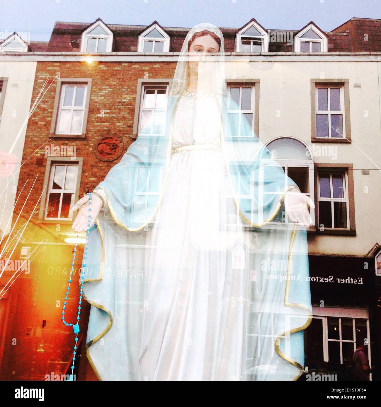 Virgin Mary reflection in window Stock Photo