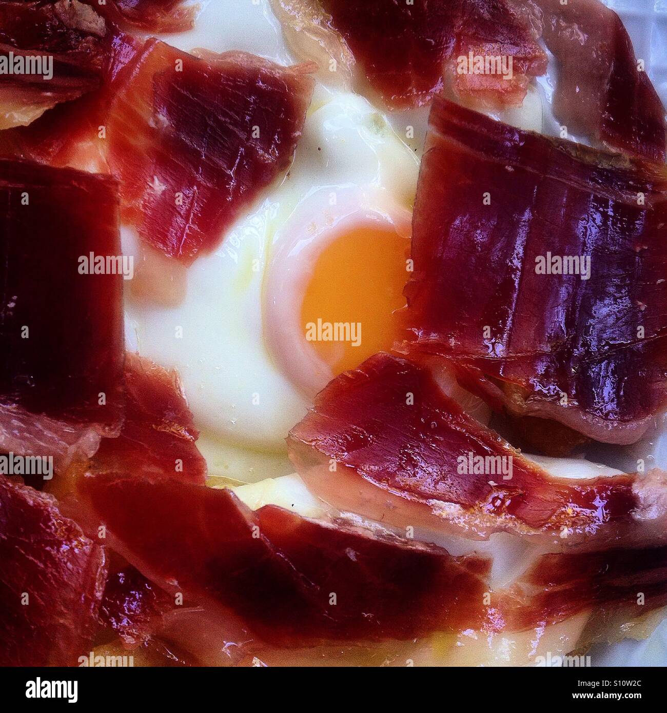 Organic Iberian ham covers an organic free-range fried egg in Prado del Rey, Sierra de Cadiz, Andalusia, Spain - Smartphone Captured Stock Image