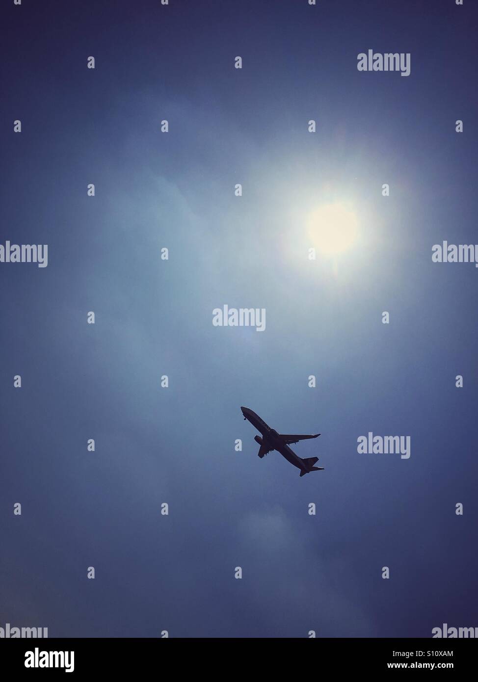 Airliner flying on a hazy sunny day - Smartphone Captured Stock Image