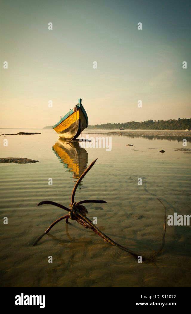 Boat with anchor on the beach during low tide - Smartphone Captured Stock Image