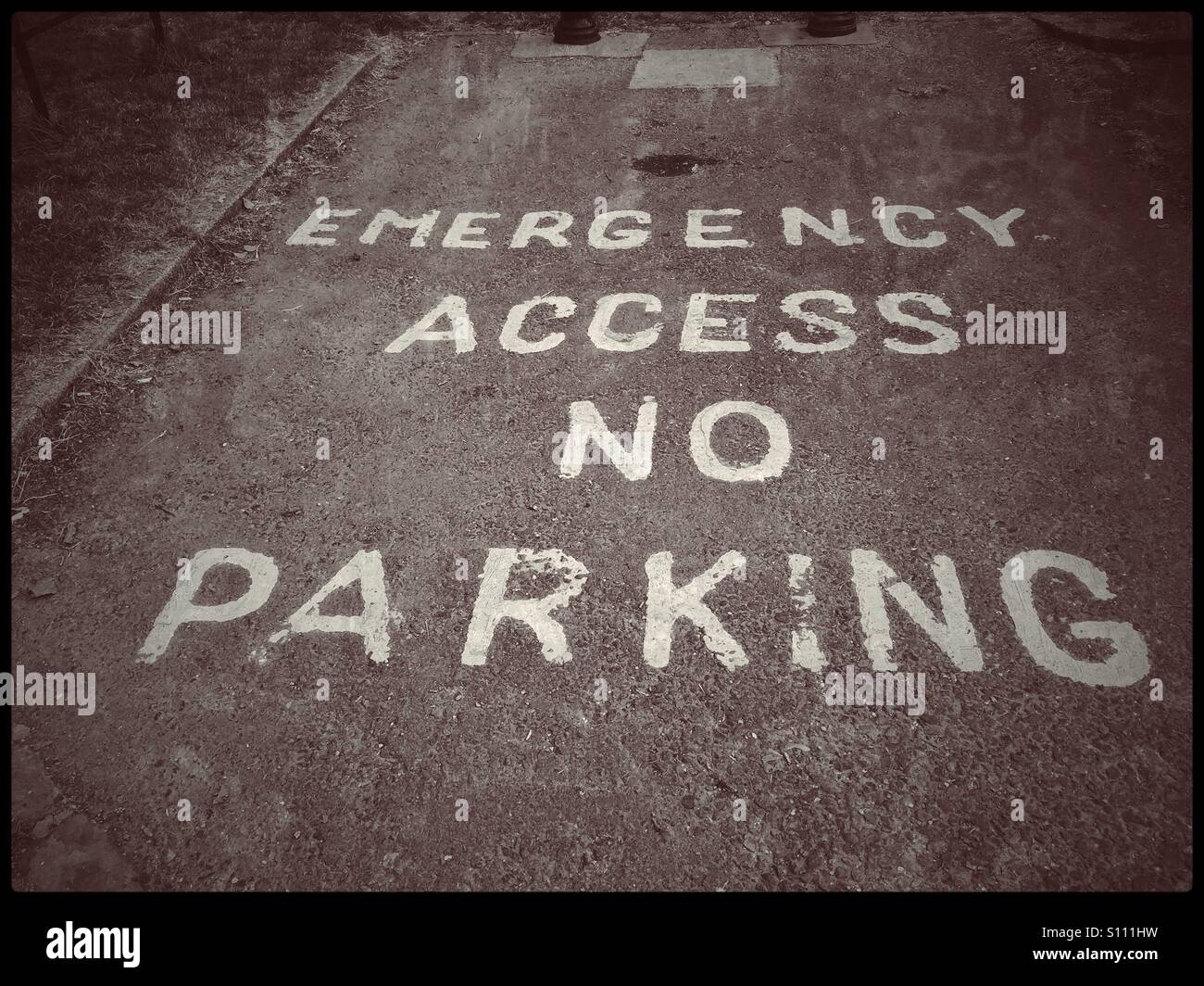 'Emergency Access No Parking' Written instructions in a car parking space advising no vehicle is to be parked in this space as it is always needed for Emergency Access. Photo © COLIN HOSKINS. - Smartphone Captured Stock Image