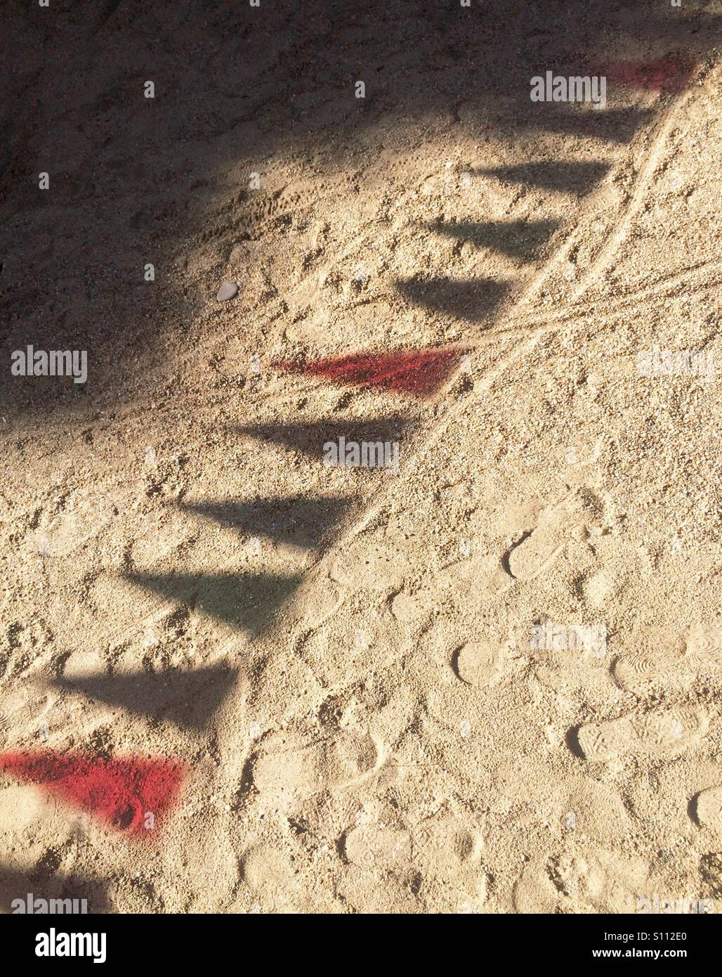 Colored shadow of bunting flags on sand surface - Smartphone Captured Stock Image