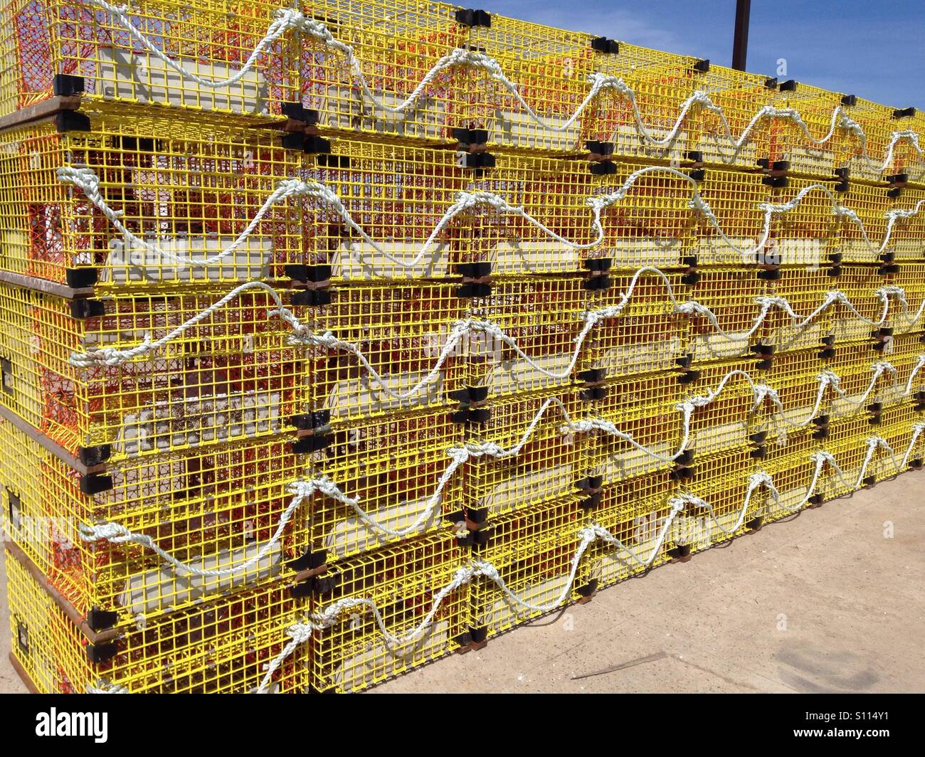 Stacked yellow metal lobster traps on the dock Stock Photo Alamy