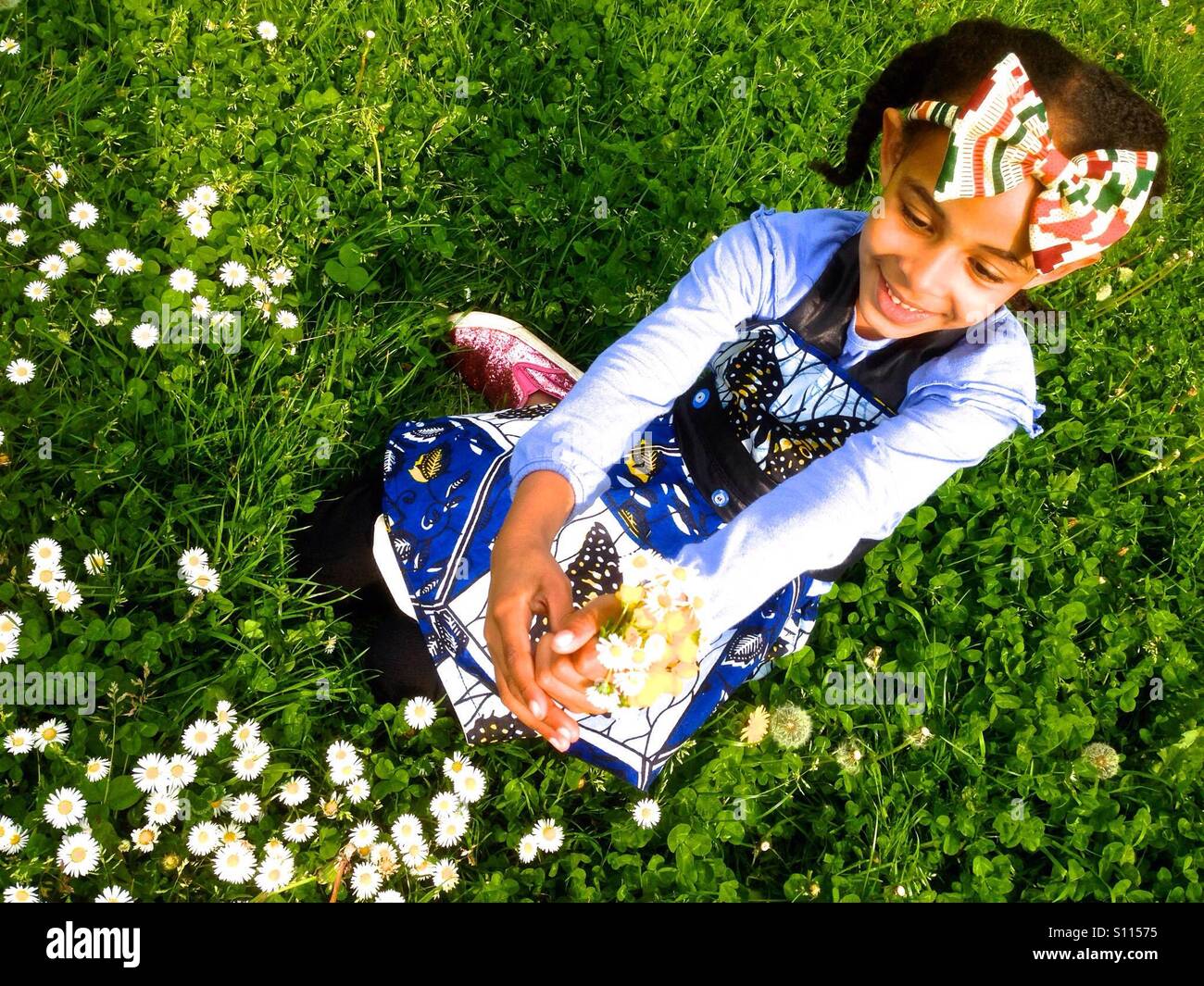 Young girl sitting on the grass with Daisy flowers Stock Photo - Alamy