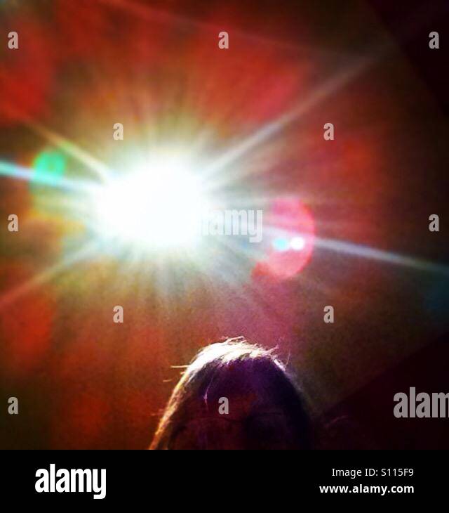 Woman sitting in a cafe with a birght light over her head. - Smartphone Captured Stock Image