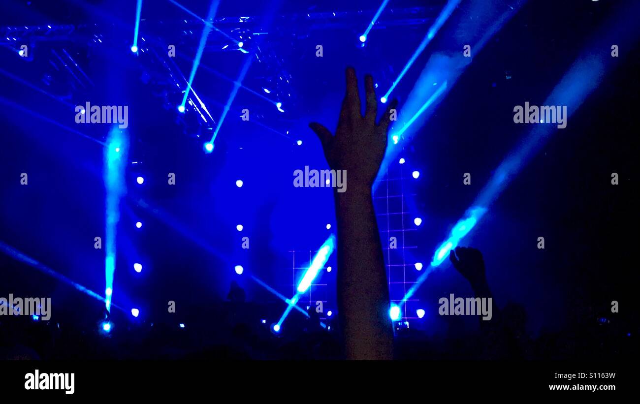 Hands in the air and blue lights - Smartphone Captured Stock Image