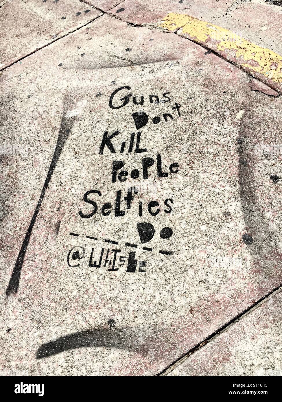 Guns don't kill Selfies do sidewalk art - Smartphone Captured Stock Image