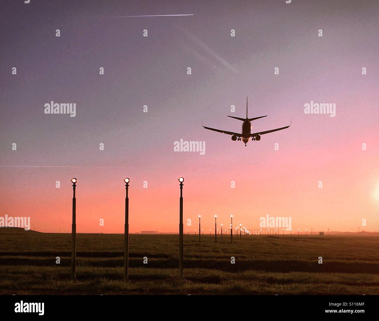 Airplane coming into land at sunset - Smartphone Captured Stock Image