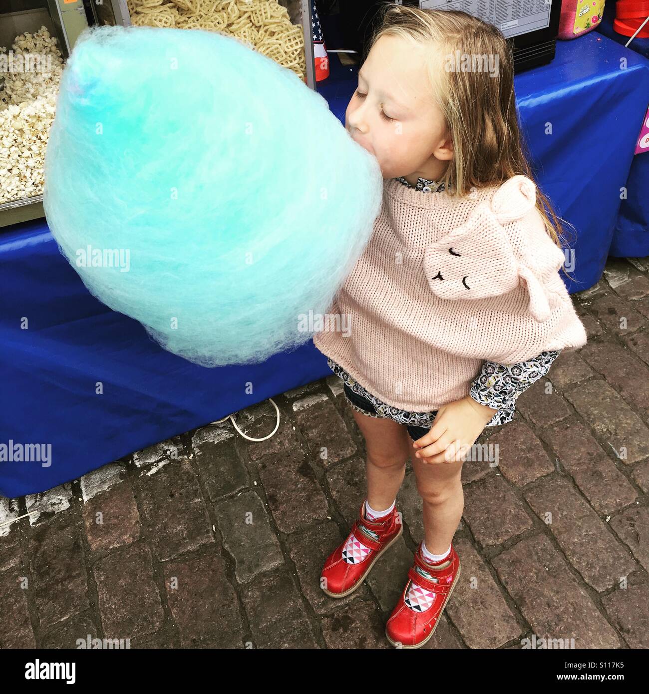 Girl eating blue candy floss Stock Photo