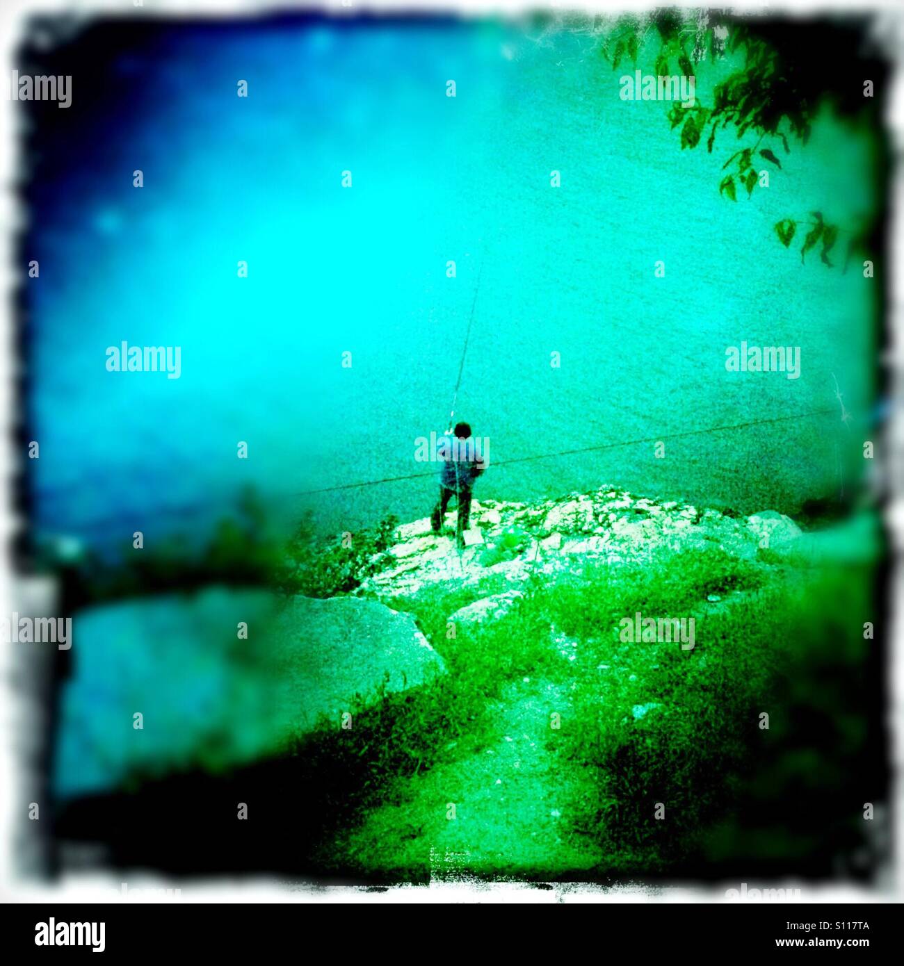 Man fishing off rocks, Balaklava bay, Crimea - Smartphone Captured Stock Image