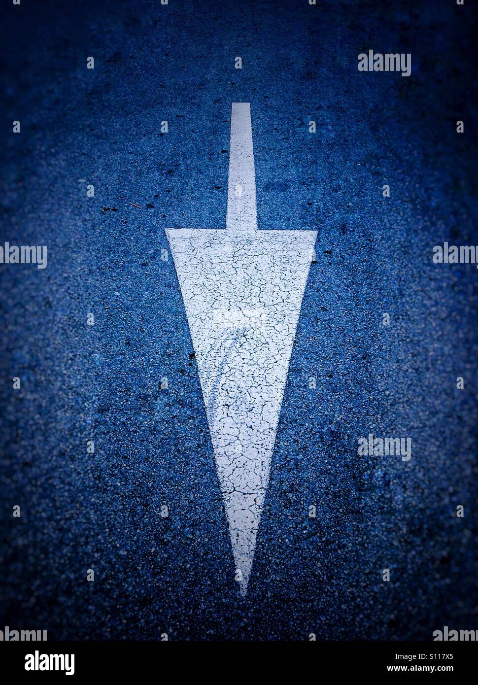 Down white arriw painted on road - Smartphone Captured Stock Image