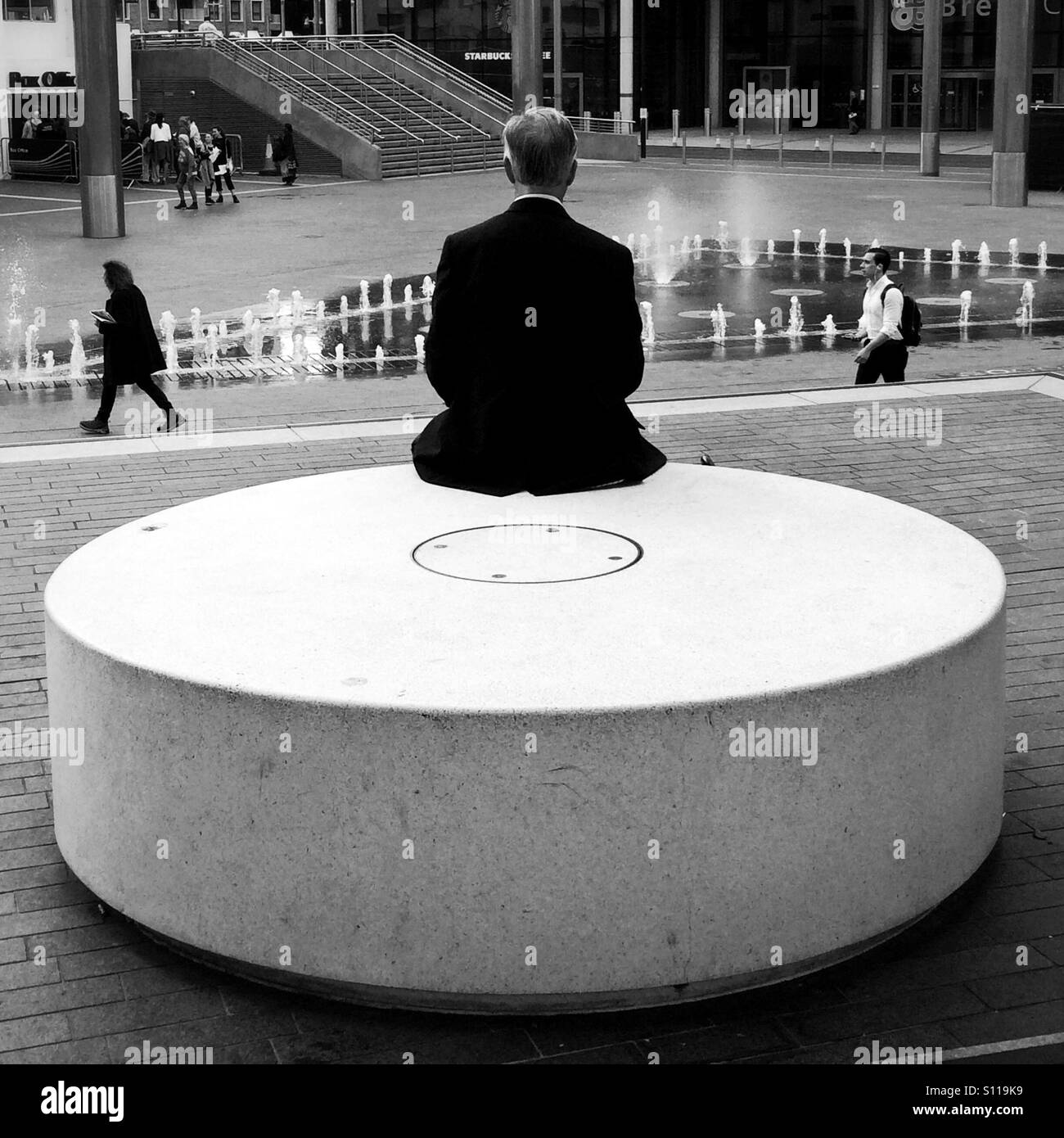 Man sitting on circular block of concrete - Smartphone Captured Stock Image