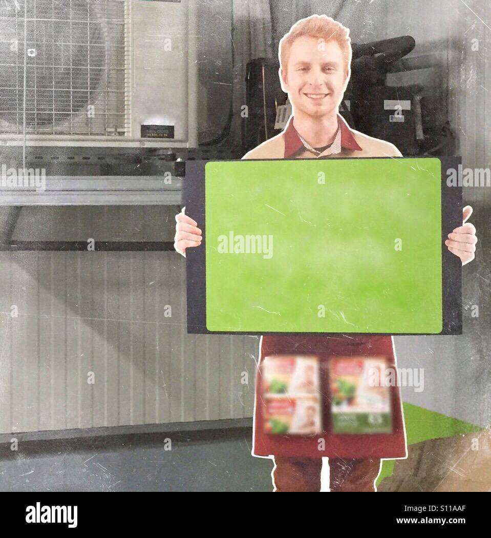 Carton cutout of a life size person holding a empty billboard in a forgotten corner of a shop storage space - Smartphone Captured Stock Image