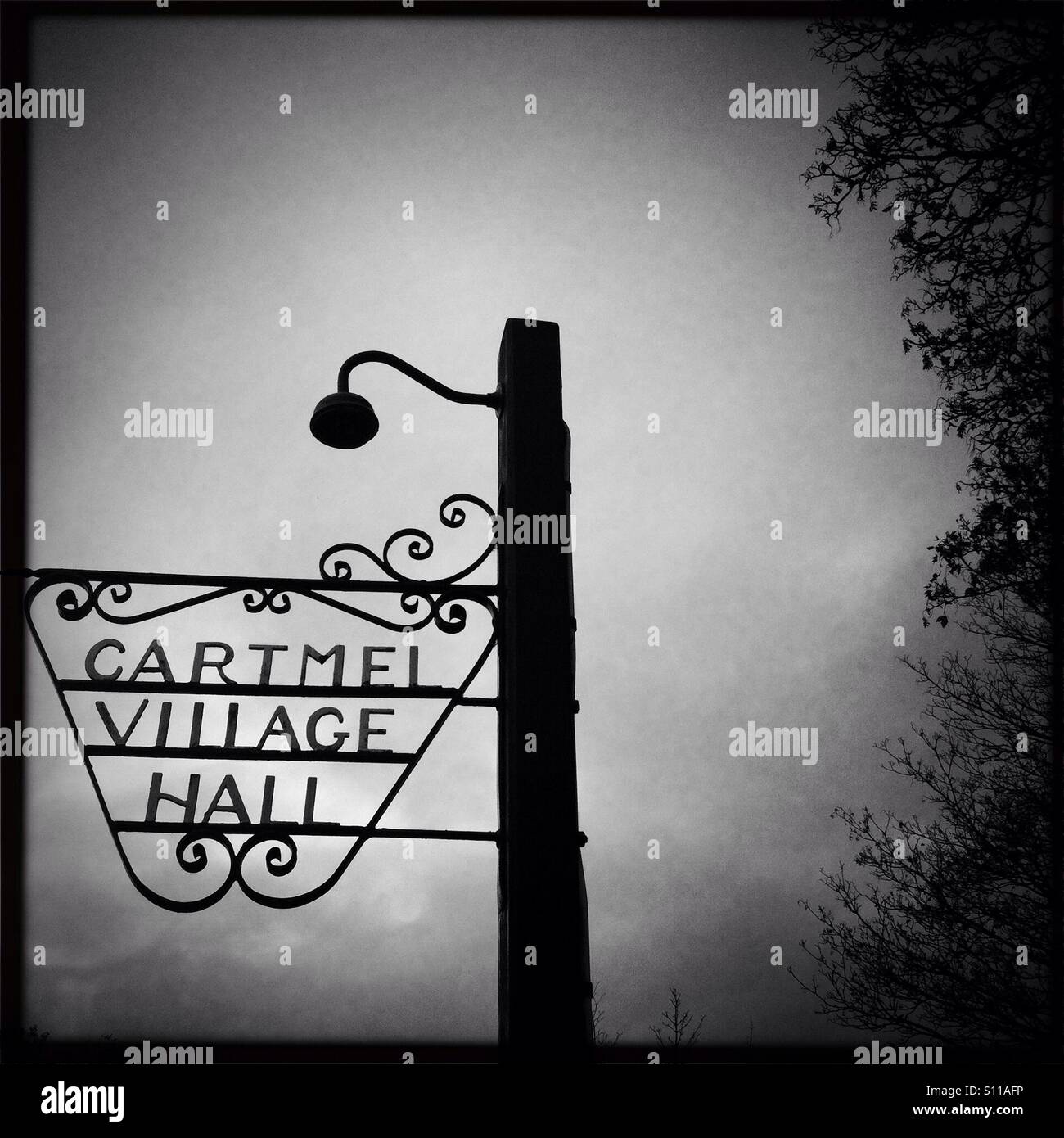 Wrought iron sign and lamp post, Cartmel village hall, Cumbria Stock Photo