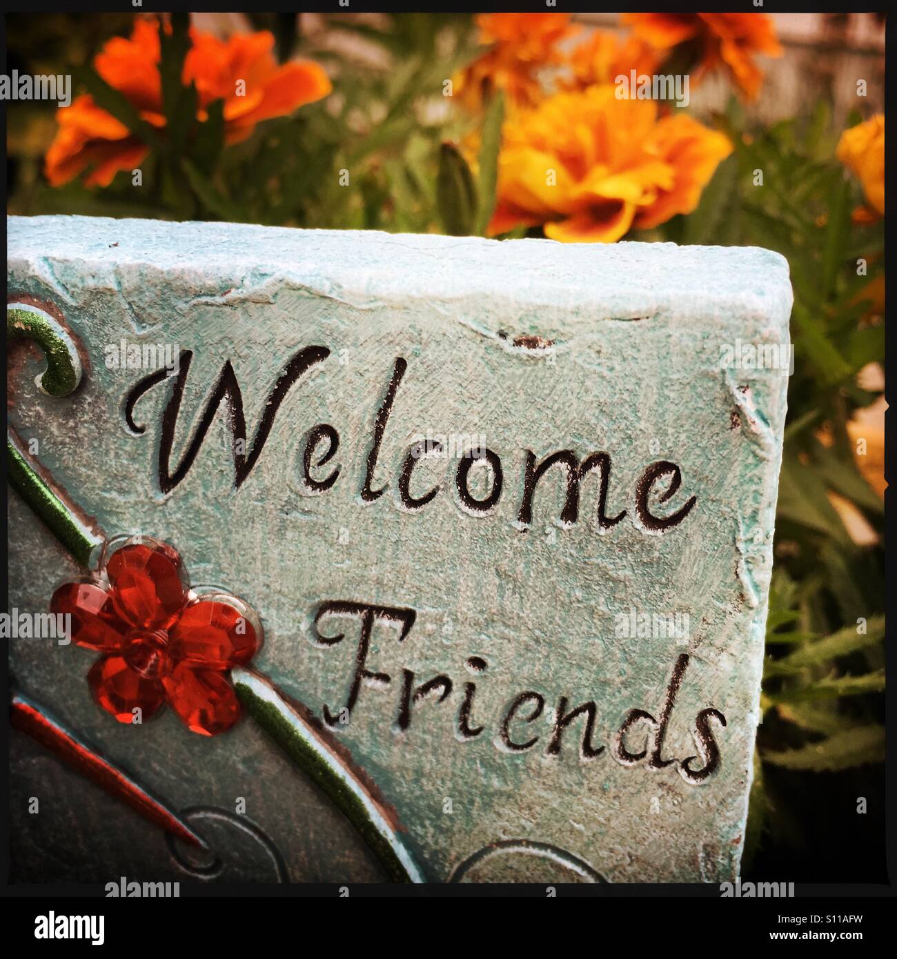 A welcoming sign with marigolds in background. - Smartphone Captured Stock Image
