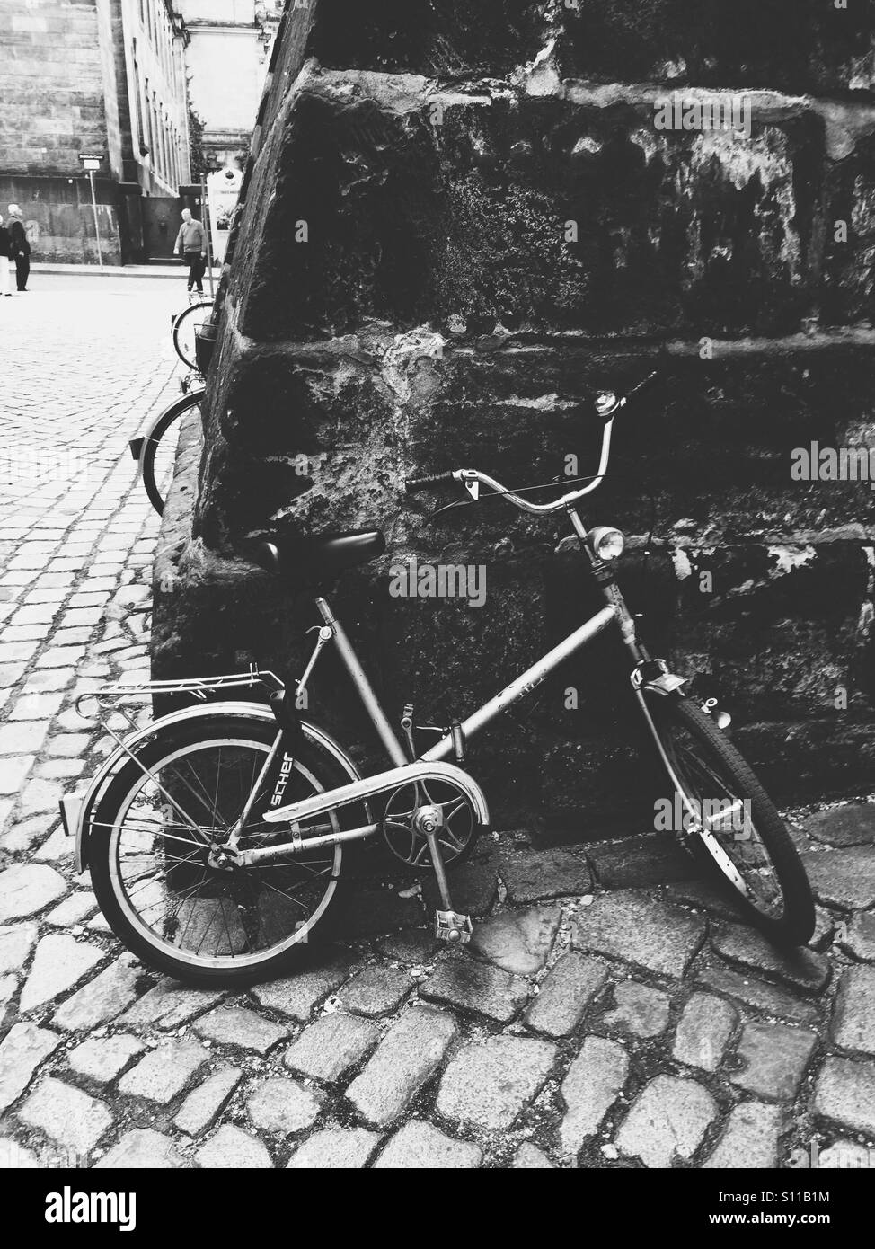 Old used bicycle parked to the wall - black and white - Smartphone Captured Stock Image