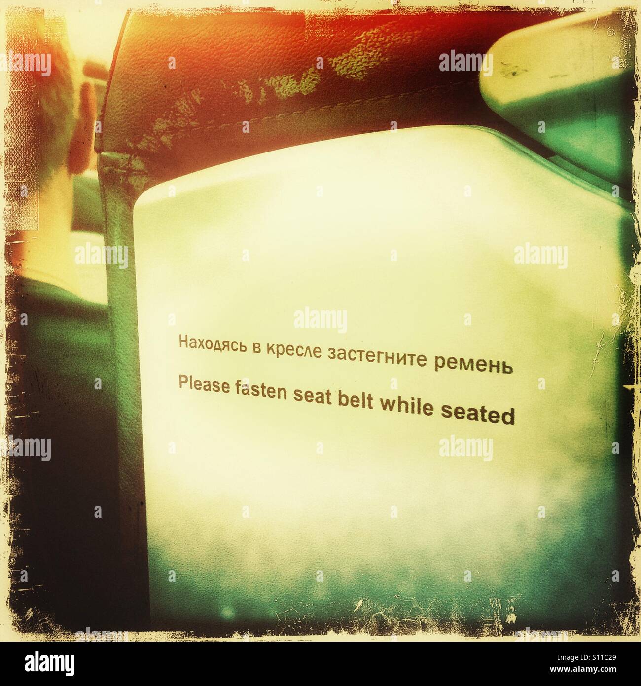 Fasten seat belt sign in English and Russian - Smartphone Captured Stock Image